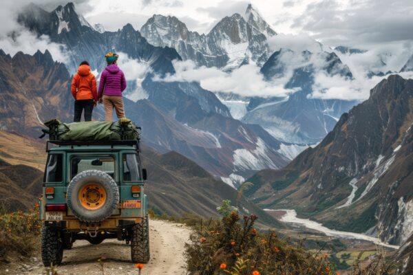 traveling-with-off-road-car best travels in trivandrum/two tourists stand on top of a jeep looking at the Himalayas